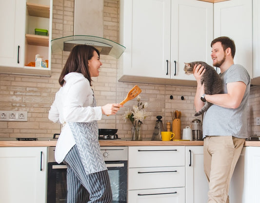 couple in the kitchen with their cat - feline nutrition blog