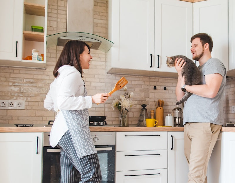 couple in the kitchen with their cat - feline nutrition blog